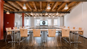 A conference room with a long table, multiple chairs, and a large screen at the front. - Speidel's Brau Manufaktur (Hohenstein)
