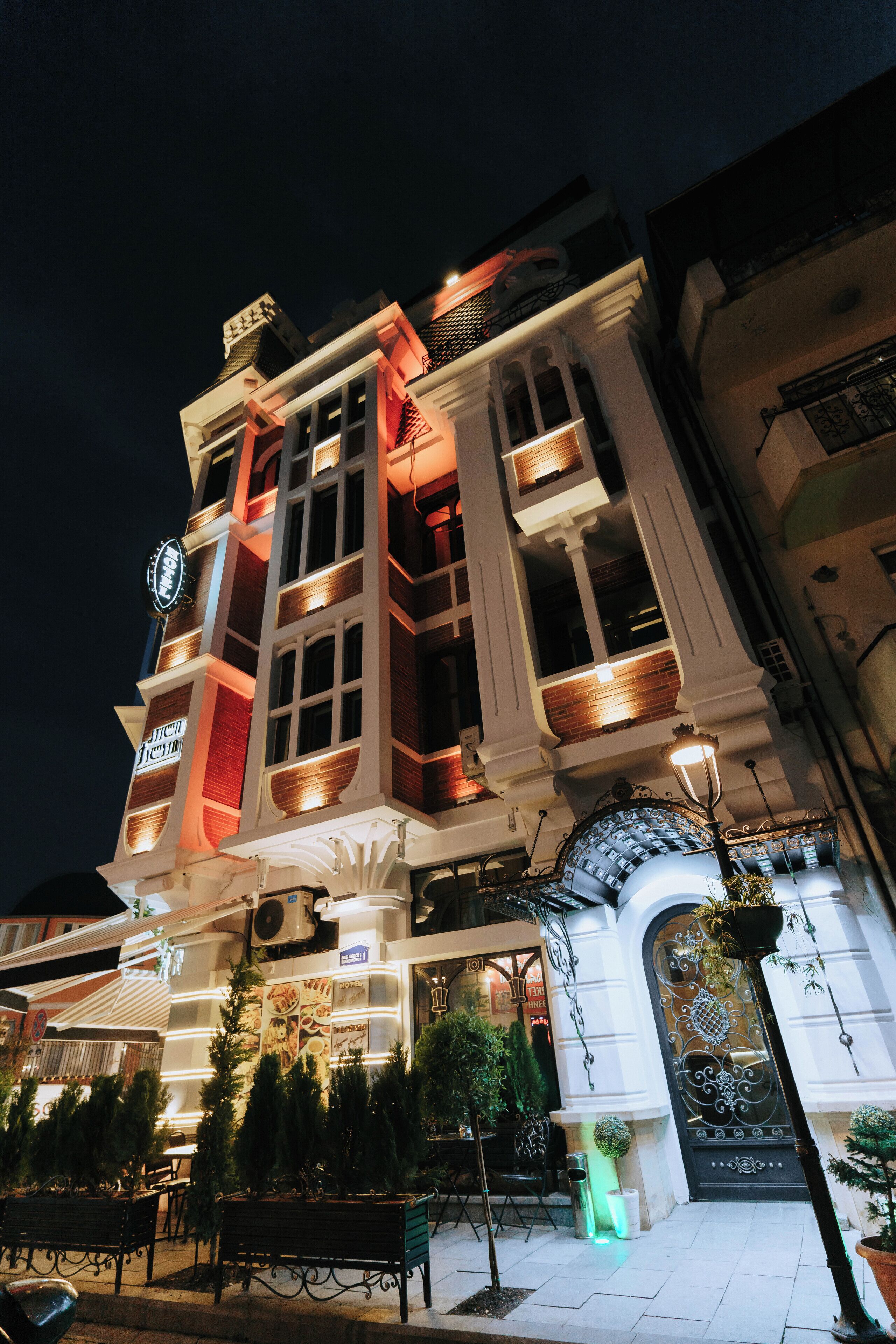 Un edificio histórico con arquitectura ornamentada, que incluye una entrada imponente y varios balcones.