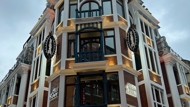 Un edificio en esquina con un letrero llamativo que dice 'Old Town', otro que dice '3,000 Cats' y uno más que dice 'KOLSKI'.