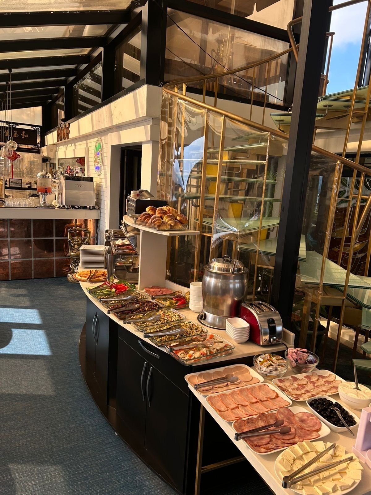 A buffet setup with various food items and a coffee station.