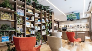Un interior moderno con estanterías, plantas y zonas de estar.
