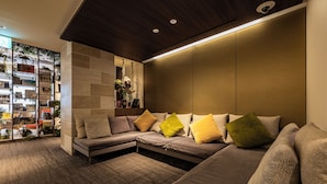 Una sala de estar moderna con un sofá modular, una estantería empotrada y un detalle decorativo en la pared.