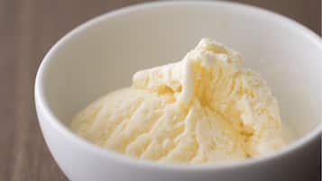 A white bowl containing a scoop of ice cream.