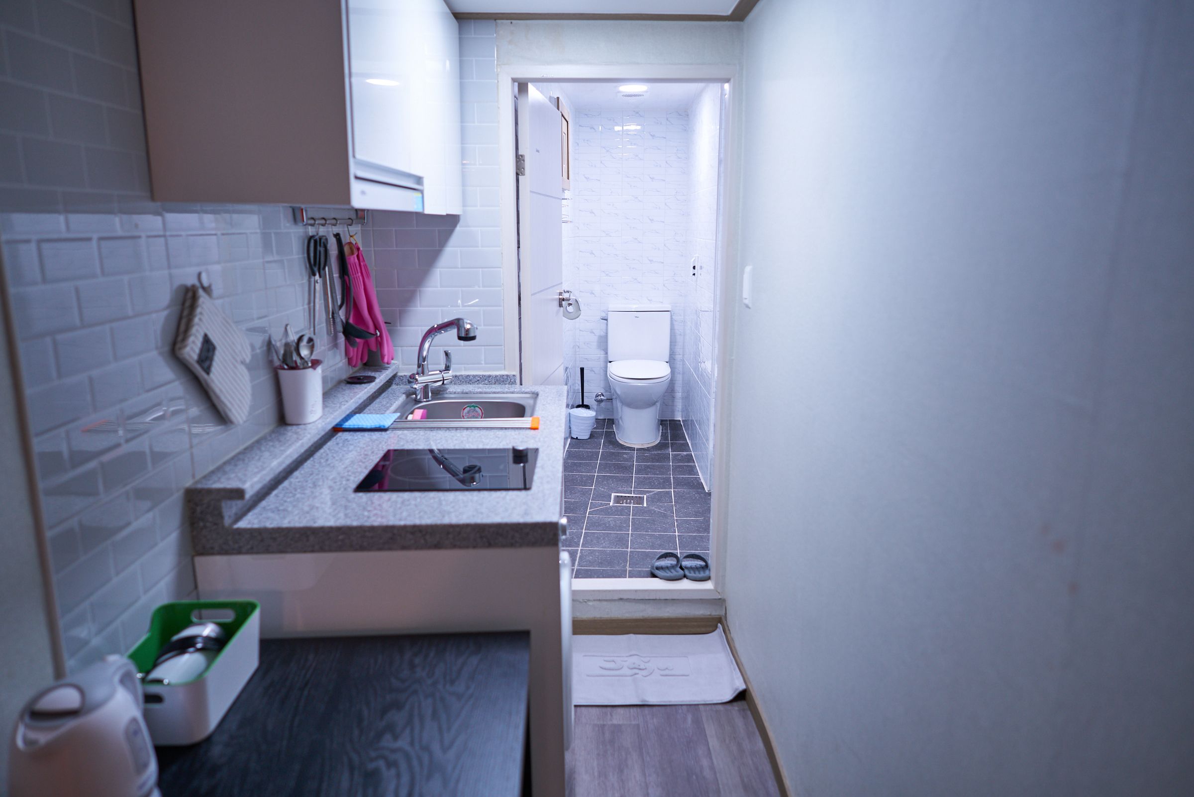 A compact bathroom with a sink, toilet, and shower.