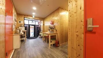 A wooden interior with a kitchen area, a dining table, and a fire extinguisher.