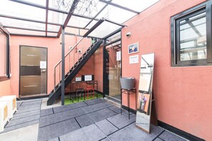 A modern interior with a staircase, a small seating area, and a glass door leading to another room.