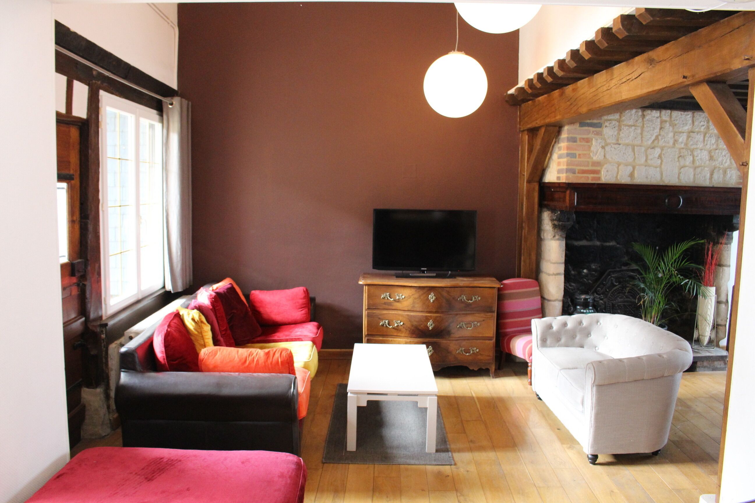 A living room with a fireplace, a television, and a sofa.
