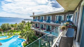 Enjoy breathtaking ocean views from the spacious pool surrounded by lush greenery and palm trees.