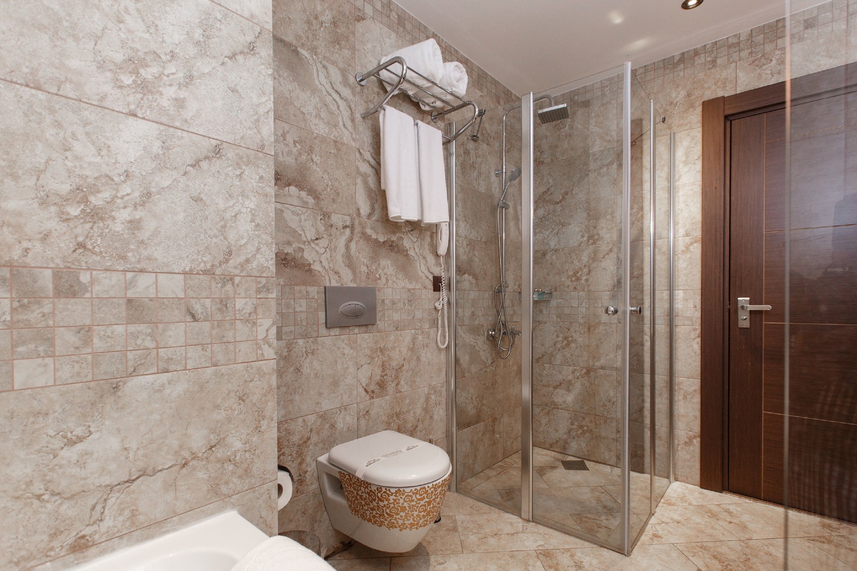 A bathroom with a glass-enclosed shower, a toilet, and a bathtub.