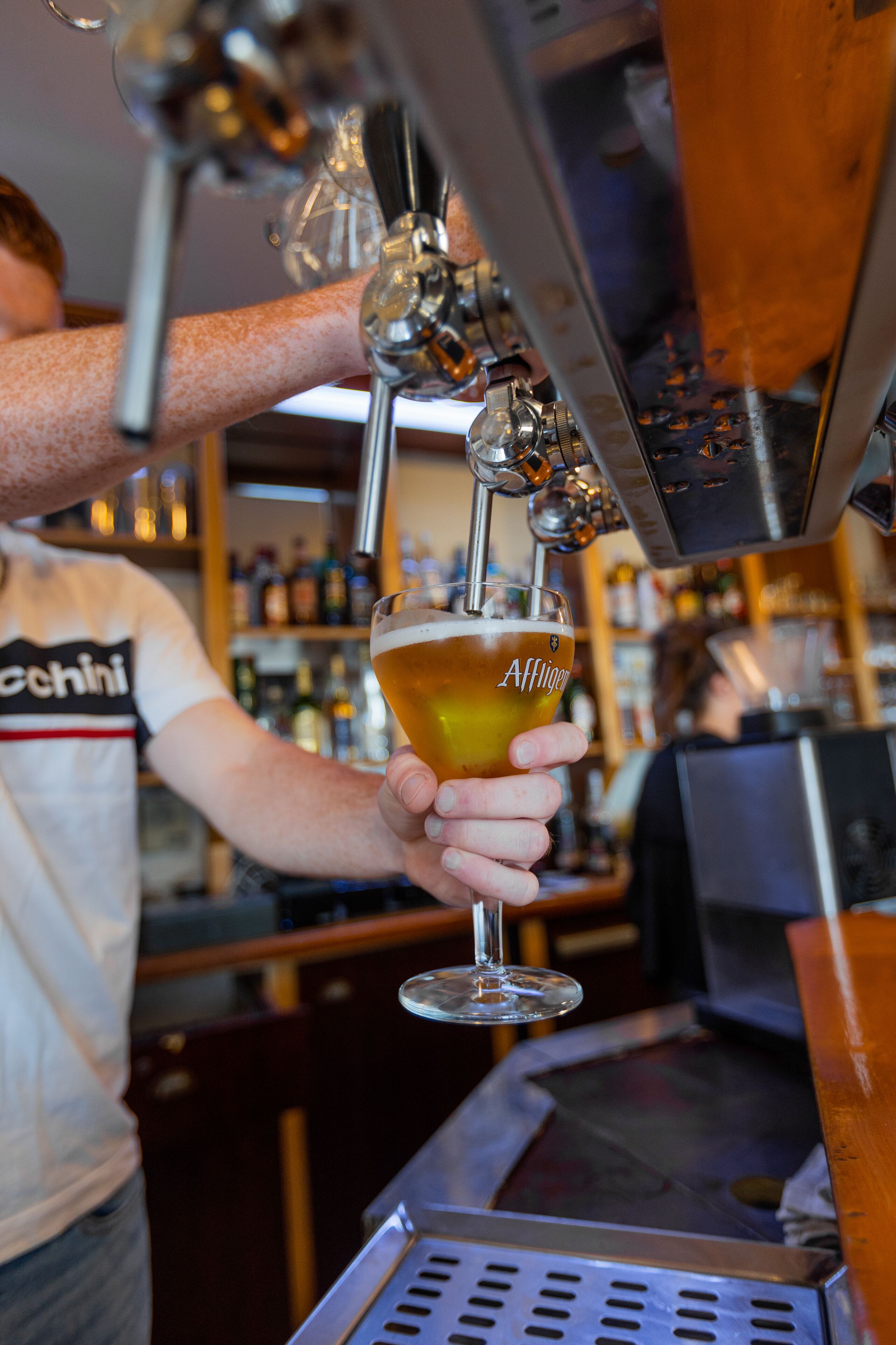 A bartender pouring beer into a glass.