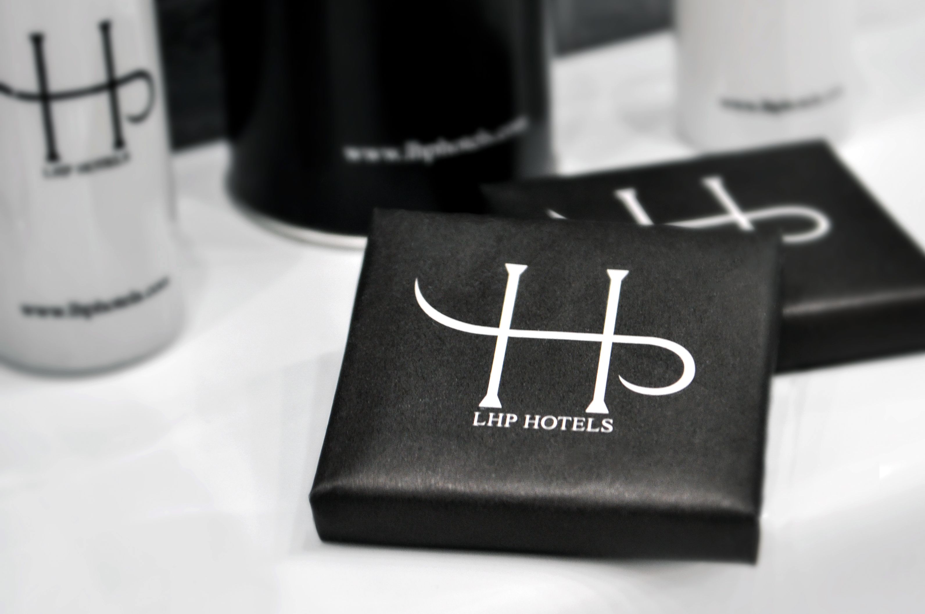 Black and white LHP Hotels branded items on a table.