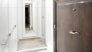 Un couloir avec une porte en bois et un meuble blanc.