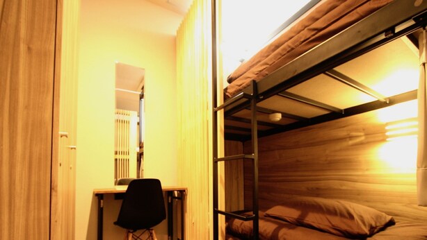 A compact room with a bunk bed, a desk, and a chair. - Namba Guesthouse HIVE - Hostel (Osaka)