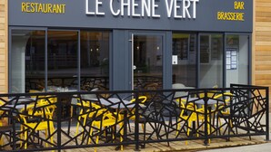 A restaurant named "Le Chêne Vert" with outdoor seating and a black metal fence. - Le Chêne Vert (Savenay)