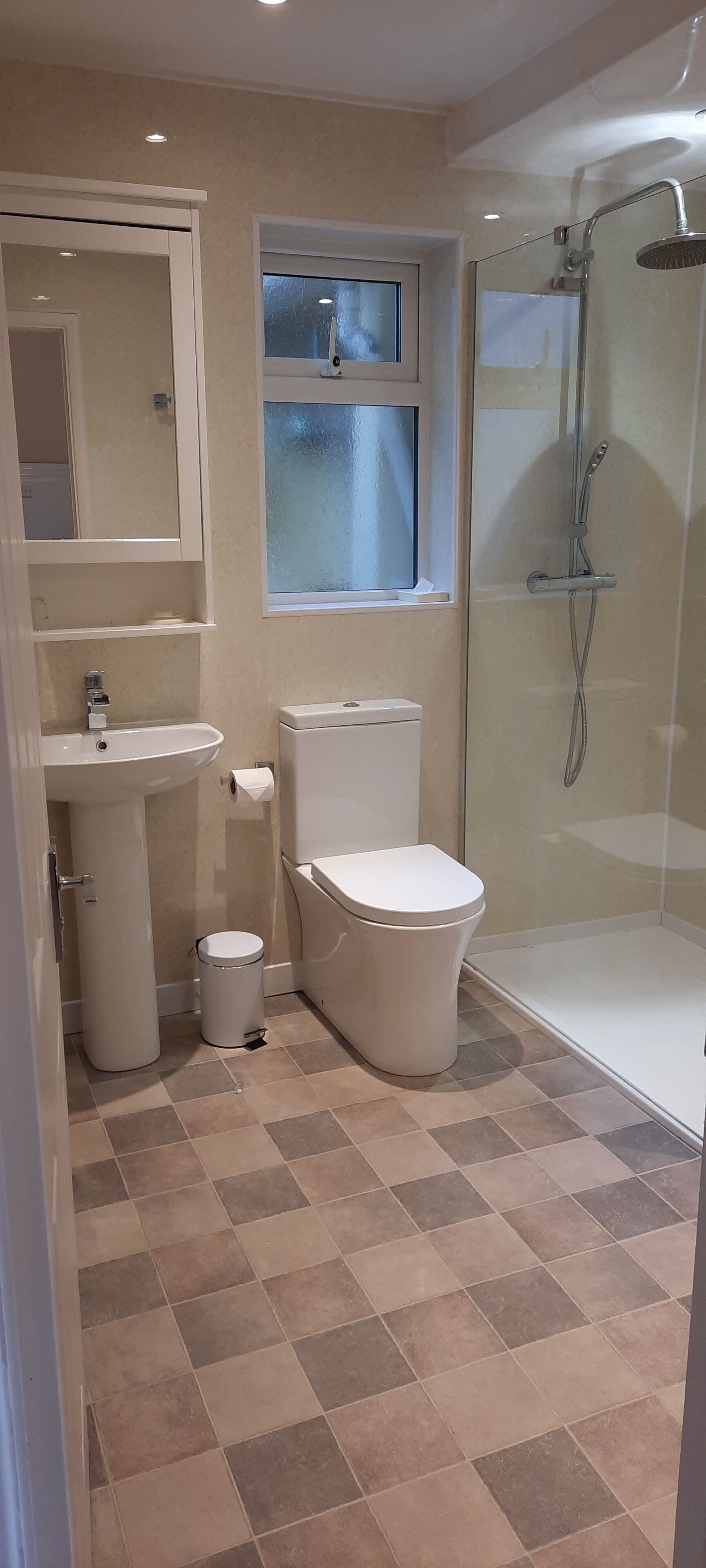 A bathroom with a toilet, sink, and shower.