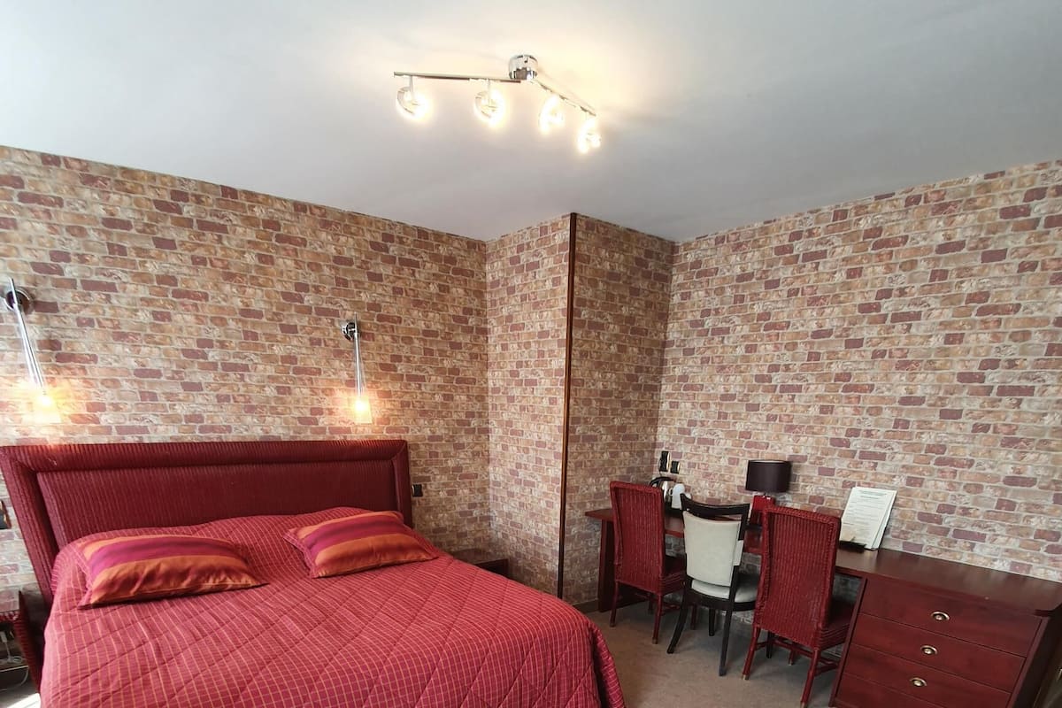 Un dormitorio con una cama grande, un escritorio y una silla.