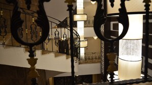 Un escalier orné de rampes noires et comportant de nombreuses lampes décoratives.