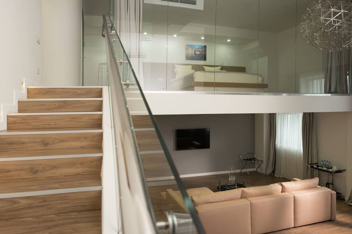 A modern living space with a staircase, a sofa, and a flat-screen TV.