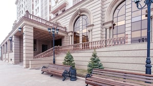 A building with a grand entrance, a staircase, and two benches. - Alanda Hotel (Astana)