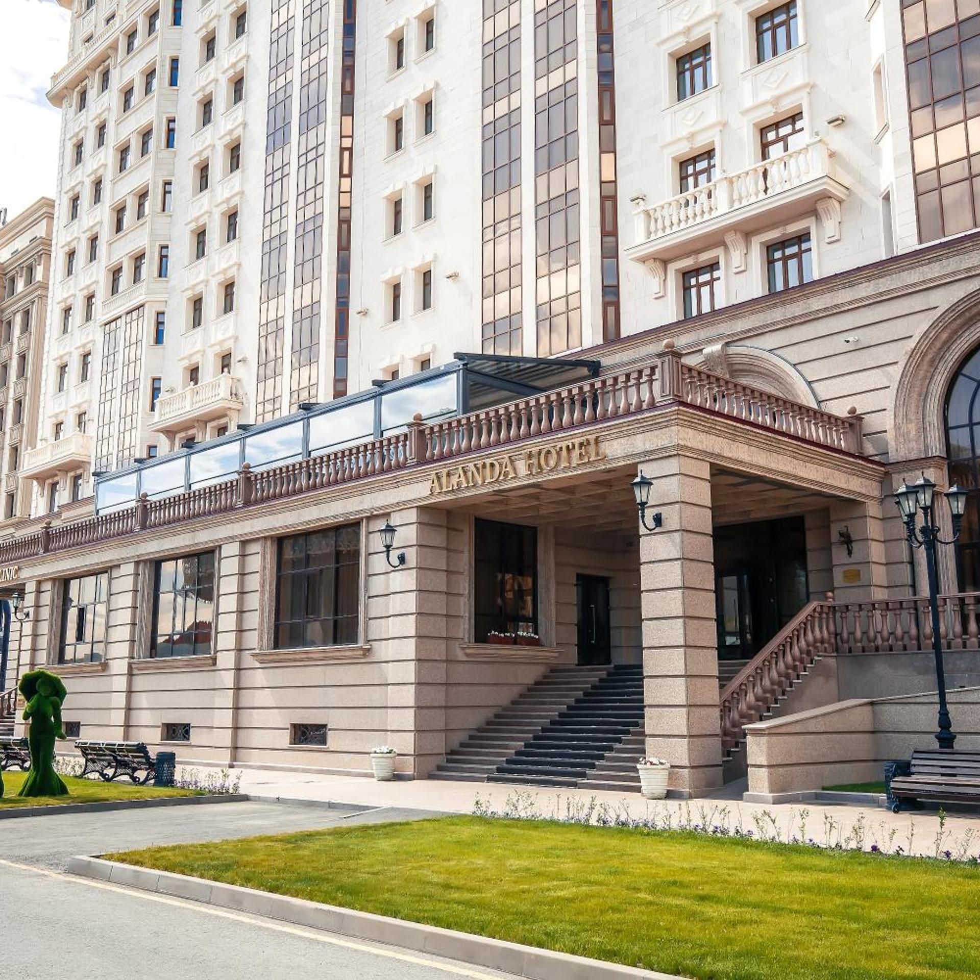 A hotel with a classical facade, a grand entrance, and a staircase leading to the entrance.