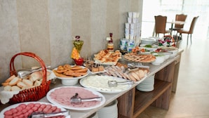 A buffet with various food items and utensils. - L Plaza Hotel (Tbilisi)