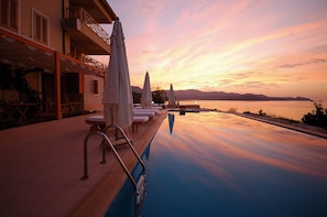 Piscina externa, guarda-sóis, espreguiçadeiras
