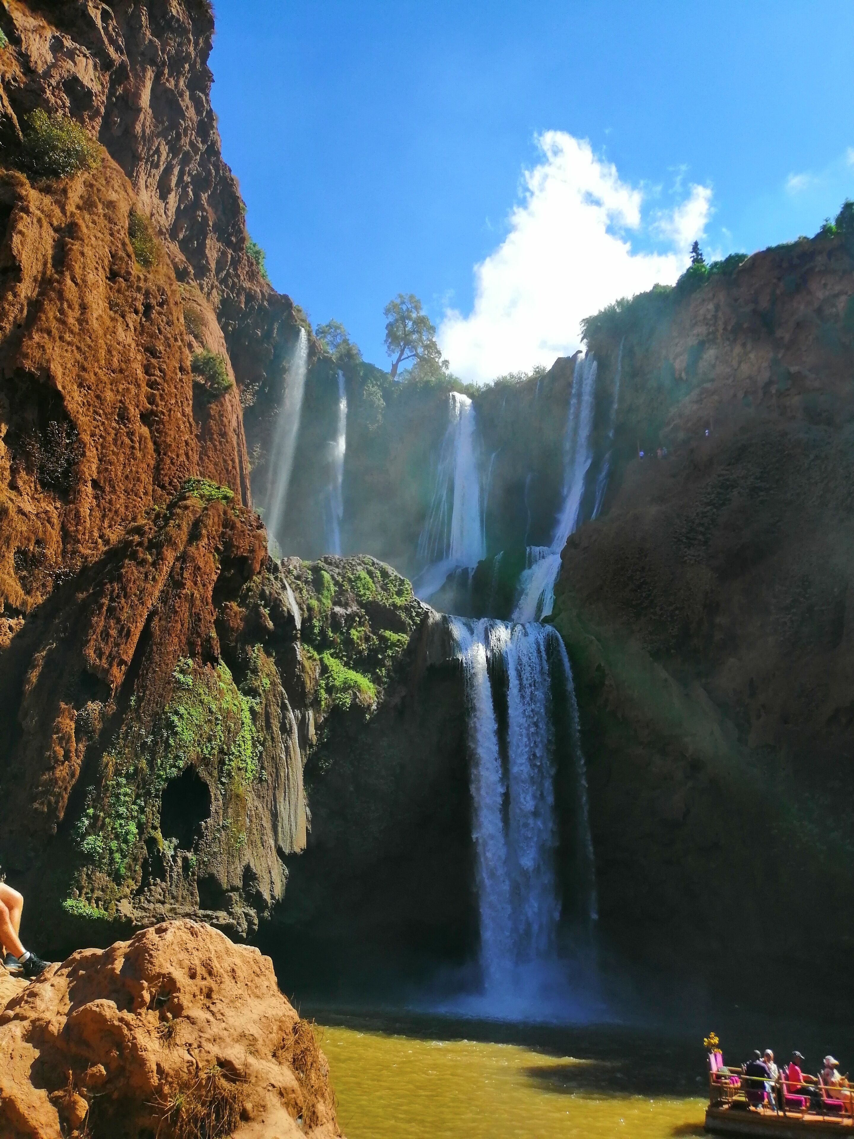 A waterfall cascading into a pool surrounded by rocky cliffs.
