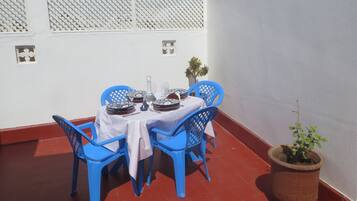A dining table set with blue chairs, white tablecloth, and decorative plates.