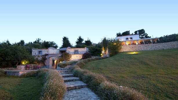 A stone pathway leading to a building with a stone facade and a small window.
