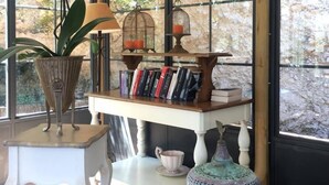 A cozy reading nook with a bookshelf, a lamp, and a potted plant.