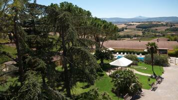 Alberca techada, alberca al aire libre y camastros