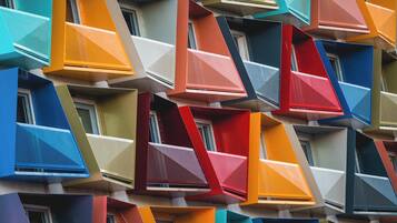 A building facade with multiple balconies featuring geometric shapes and vibrant colors.