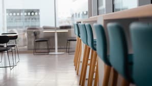 A modern dining area with wooden tables and teal chairs, large windows, and a clean, minimalist design. - Holiday Inn Express Malta by IHG (St. Julian's)