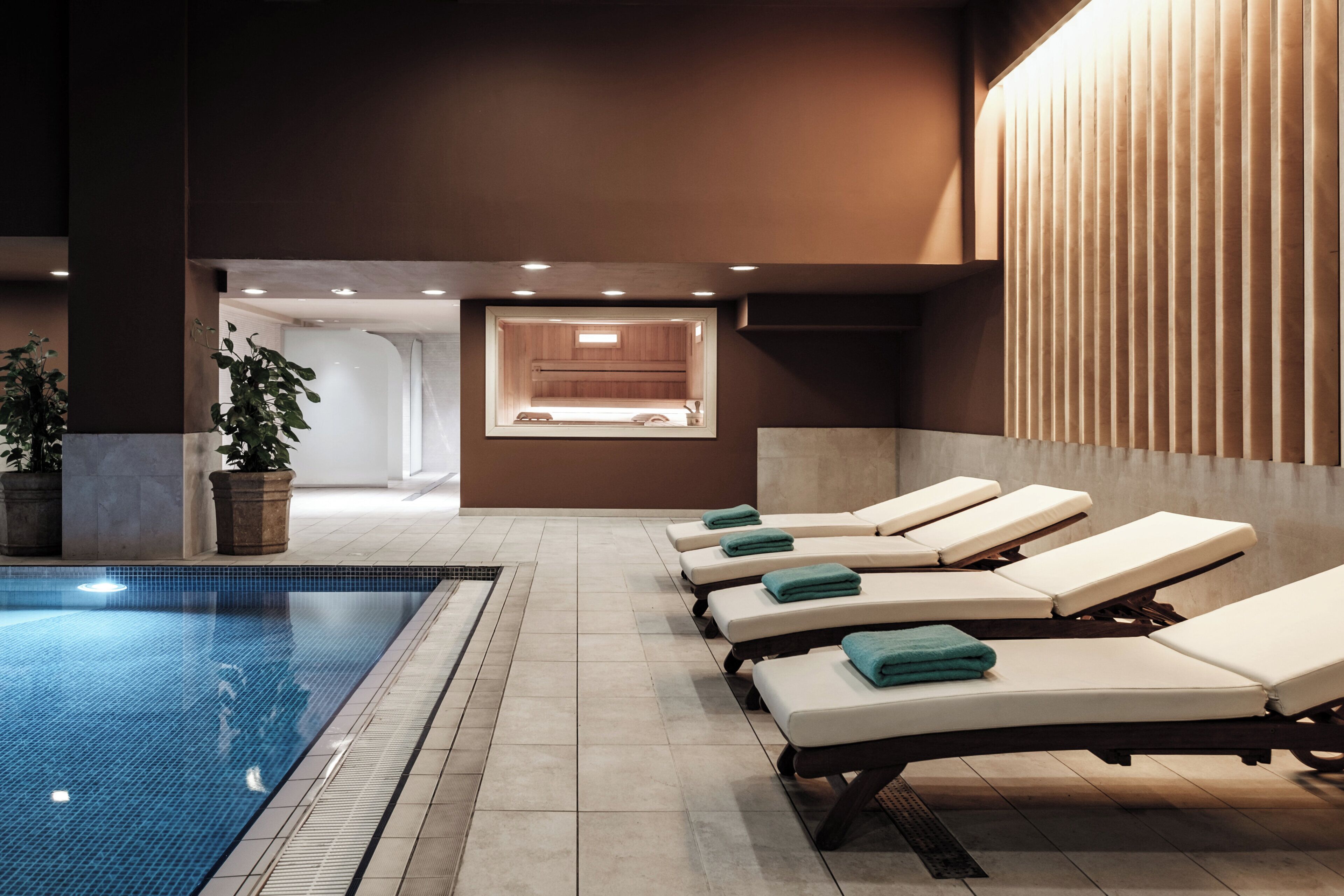 A spa area with a pool, sun loungers, and a massage room.