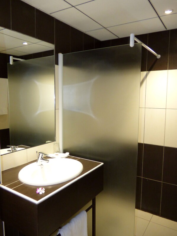 A modern bathroom with a large mirror, a white sink, and a towel rack. - Hôtel La Résidence N'Djamena (N'Djamena)