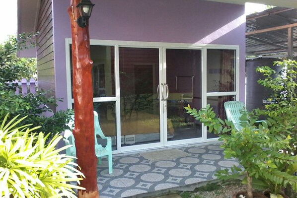 A house with a purple exterior, a sliding glass door, and a patterned patio.