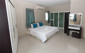 A bedroom with a bed, a desk, and a mirror. - Sirin House (Krabi)