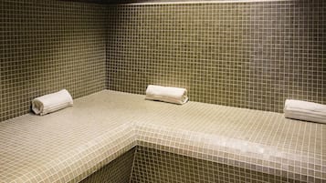 Una piscina cubierta, tumbonas