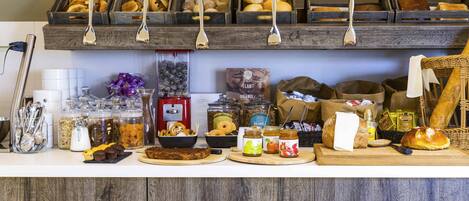 Een ontbijtbuffet met diverse soorten eten en bestek.