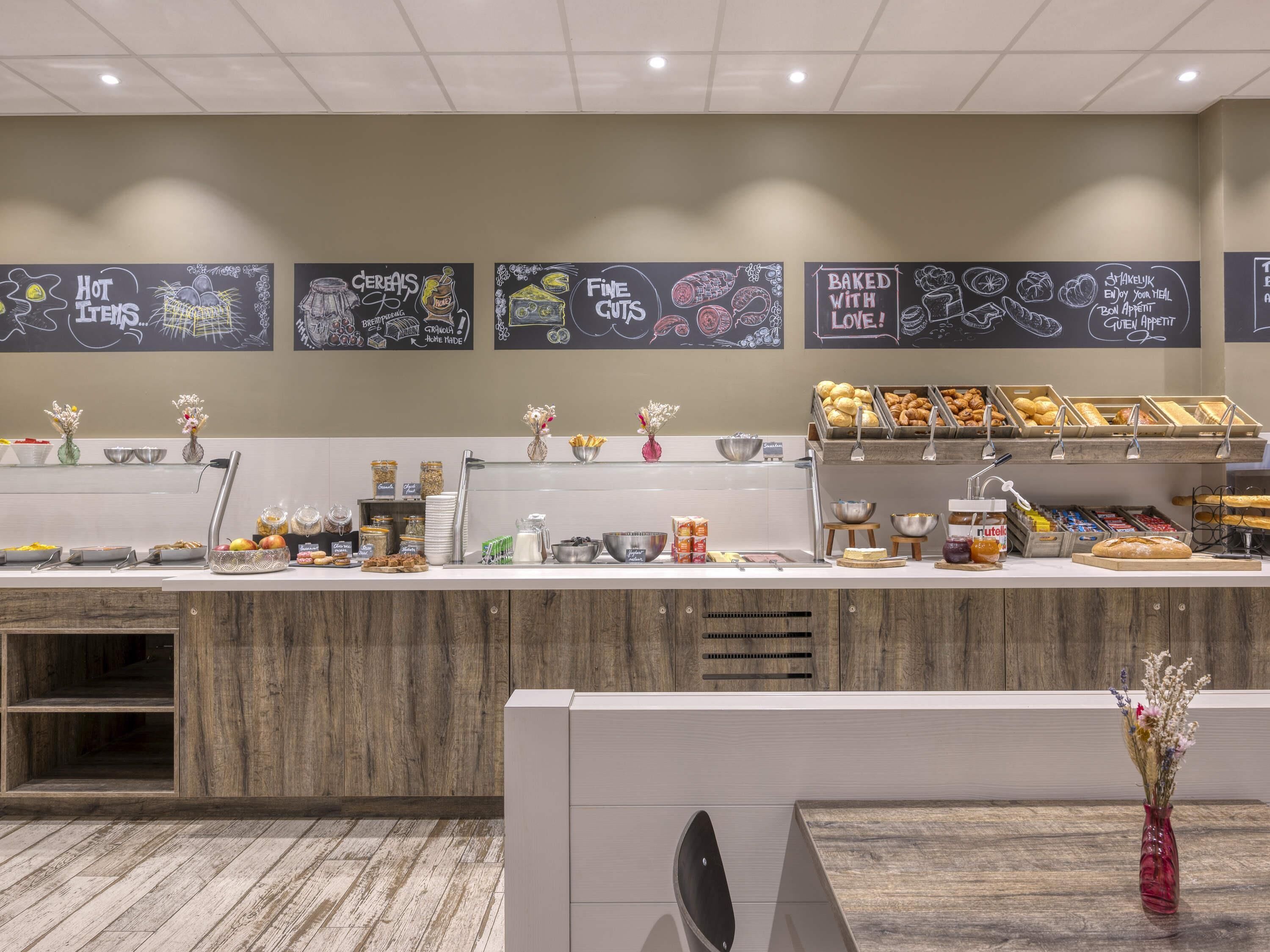 A breakfast buffet area with various food items and a chalkboard menu.