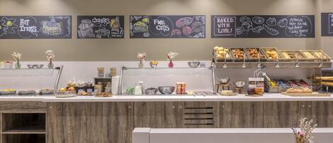 A breakfast buffet area with various food items and a chalkboard menu.
