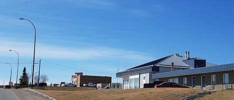 A building with a blue roof and a parking lot.
