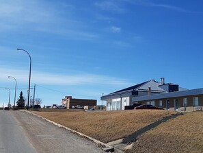 A building with a blue roof and a parking lot.