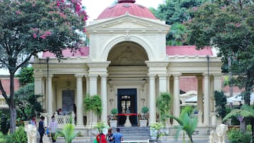 Un edificio histórico con una cúpula roja, columnas y estatuas.