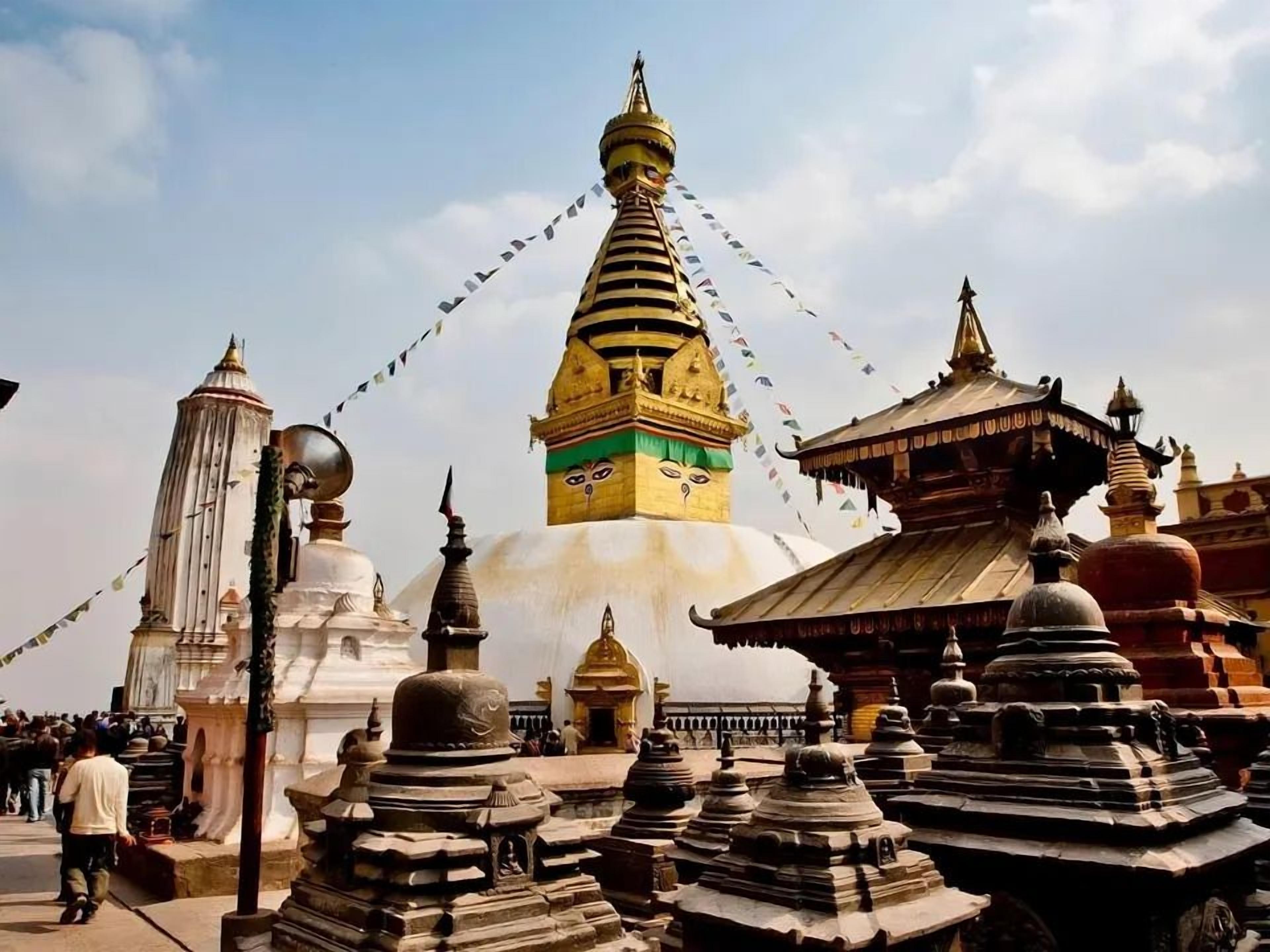 A temple complex with multiple stupas and a prominent central stupa with a golden top.