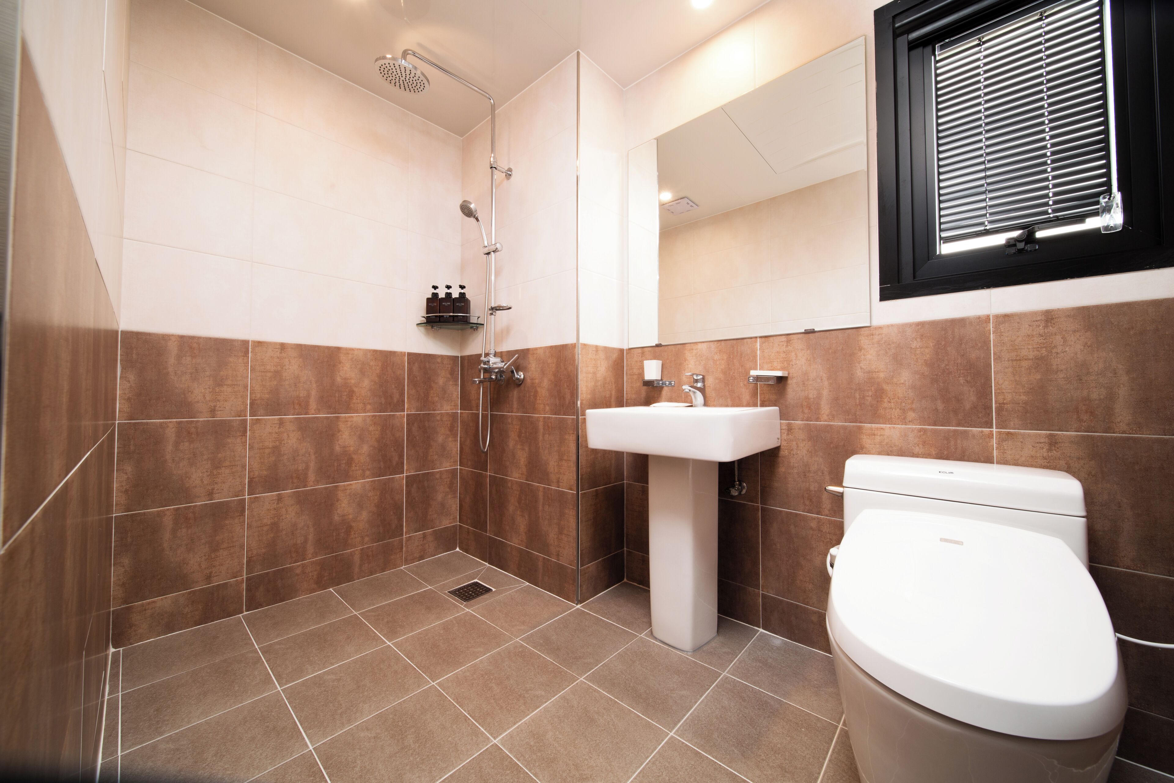 Une salle de bain avec une douche, un lavabo et des toilettes.
