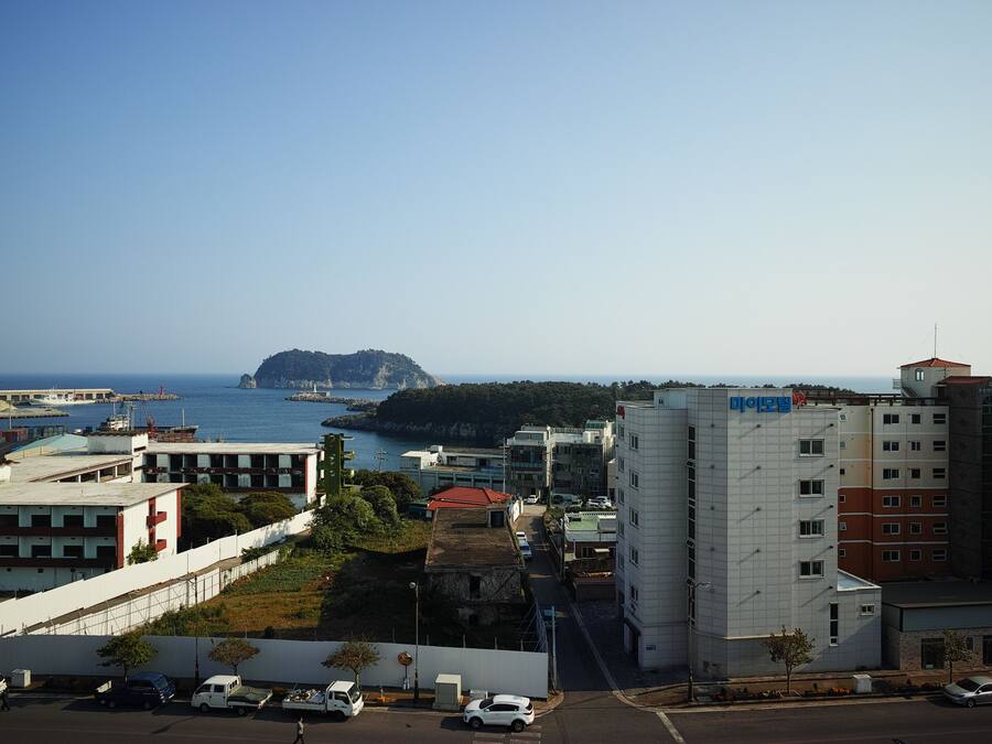 A coastal urban area with a prominent building featuring a red roof and a white facade.