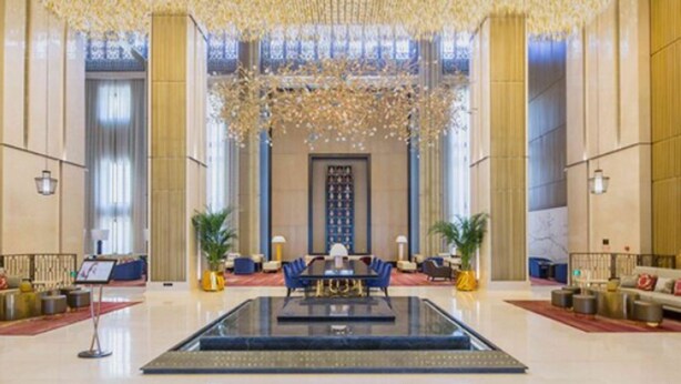 A spacious lobby with a central seating area, a large chandelier, and a reception desk. - Grand Bay Hotel Beijing (Miyun)