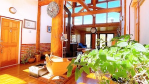 A spacious room with wooden beams, a large window, and a potted plant. - Hakuba Log Hotel Meteor (Hakuba)