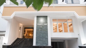 A hotel entrance with a staircase leading up to a reception area. - Veevoo Hotel (Ho Chi Minh City)